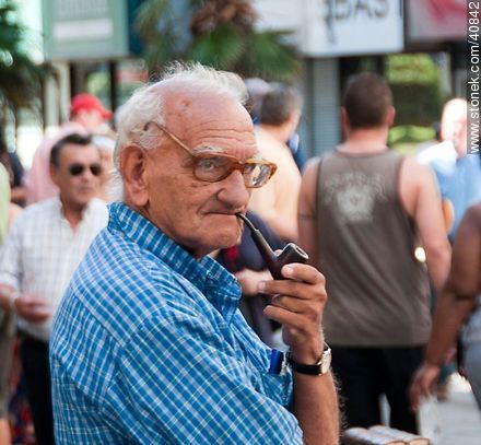 Anciano vendedor de libros fumando en pipa. - Departamento de Montevideo - URUGUAY. Foto No. 40842