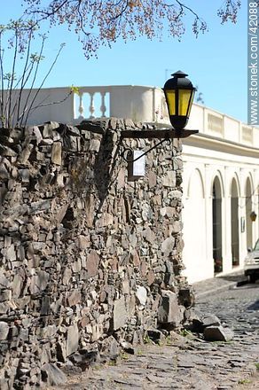 Lamp and stone wall. Del Comercio St. - Department of Colonia - URUGUAY. Photo #42088