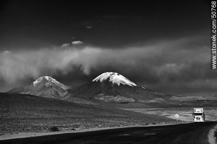 Truck on Route 11 from Bolivia. Pomerape and Parinacota volcanoes in the mountains of Nevados de Payachatas -  - MORE IMAGES. Photo #50768