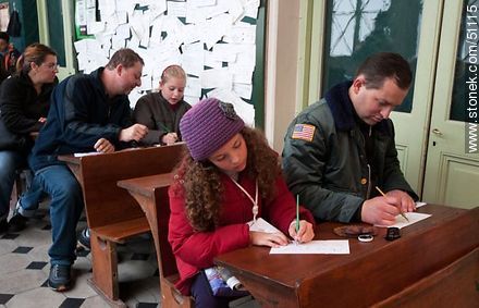 Familias en antiguos bancos escolares escribiendo con plumas y tinta en el Museo Pedagógico. - Departamento de Montevideo - URUGUAY. Foto No. 51115