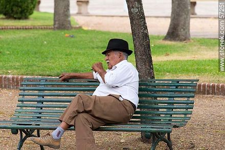 Elderly retired resting and smoking on a park bench - Department of Salto - URUGUAY. Photo #57251