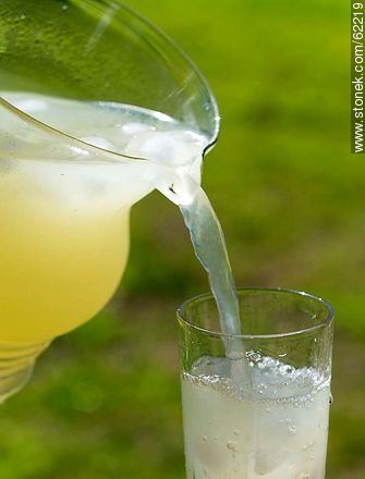 Lemonade with ice in a glass jar being served in a glass -  - MORE IMAGES. Photo #62219