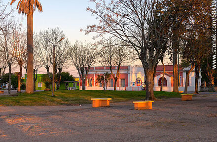 La plaza al atardecer. Al fondo la escuela y la capilla - Departamento de San José - URUGUAY. Foto No. 68419