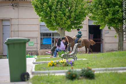 Lazaro Cabrera Square. Students chatting and horsemanship in the street - Lavalleja - URUGUAY. Photo #70692