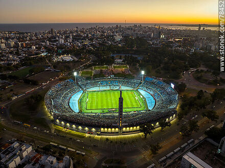 Vista aérea del Estadio Centenario iluminado al atardecer con vista de la cludad - Departamento de Montevideo - URUGUAY. Foto No. 78452