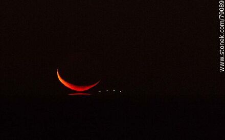 Last glint of reddish light from the new moon over the sea -  - MORE IMAGES. Photo #79089