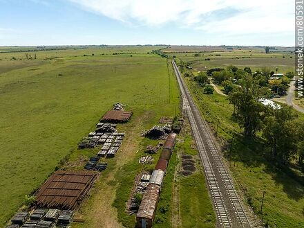 Vista aérea de la estación de trenes Queguay. Antiguos vagones, rieles y durmientes apilados - Departamento de Paysandú - URUGUAY. Foto No. 80591