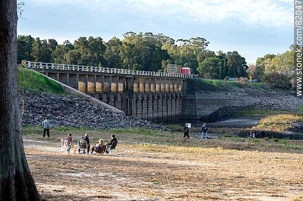 The nearly dry reservoir of Canelon Grande Creek during the drought of 2023. People sitting and strolling where the water normally is - Department of Canelones - URUGUAY. Photo #82047