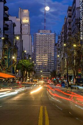 18 de Julio Avenue. Gaucho Tower. Trail of lights left by the traffic at dusk. The full moon - Department of Montevideo - URUGUAY. Photo #84524