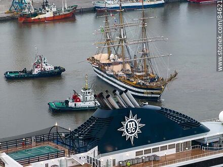 Aerial view of tugboats maneuvering with the training ship Amerigo Vespucci and the smokestack of the cruise ship MSC Poesia - Department of Montevideo - URUGUAY. Photo #84621
