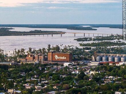 Vista aérea de la ciudad de Paysandú al atardecer. Fábrica Norteña, río Uruguay y puente a Colón (ARG.) - Departamento de Paysandú - URUGUAY. Foto No. 85902