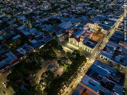 Vista aérea de la plaza Constitución, Basílica Nuestra Señora del Rosario y la calle 18 de Julio al anochecer - Departamento de Paysandú - URUGUAY. Foto No. 85915